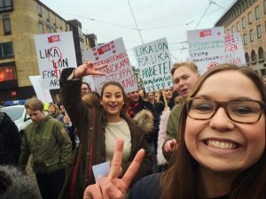 Unga människor i demonstrationståg, under paroller som "Lika lön för lika arbete - hon/han/hen" och "Internationell kvinnokamp - stoppa Saudiavtalet".