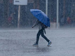 En person med paraply går genom hällregn.